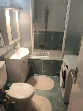 Smaller bathroom with a bathtub, washbasin, toilet, and washing machine. - image 5