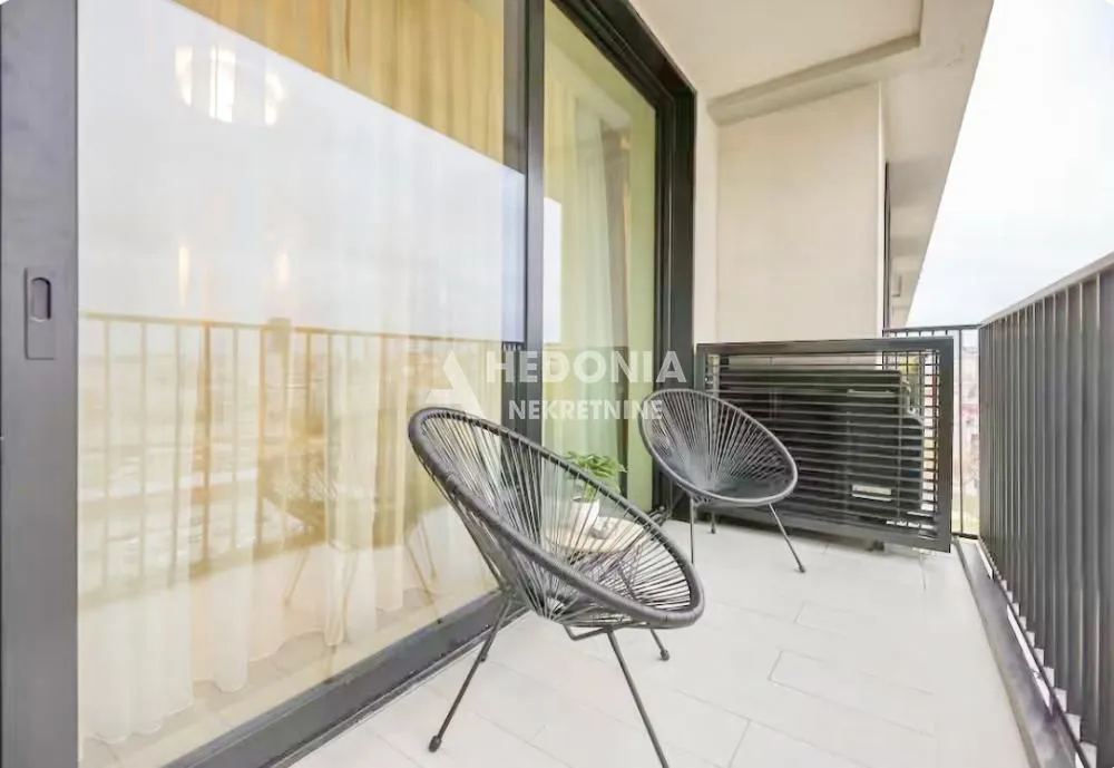 Furnished balcony with glass railing and chairs.