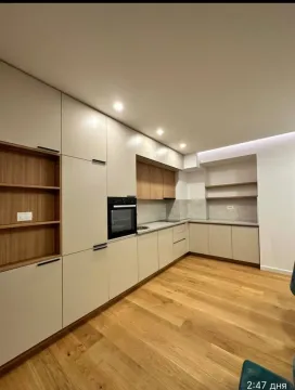 Modern kitchen with built-in cabinetry and wooden flooring. - image 2