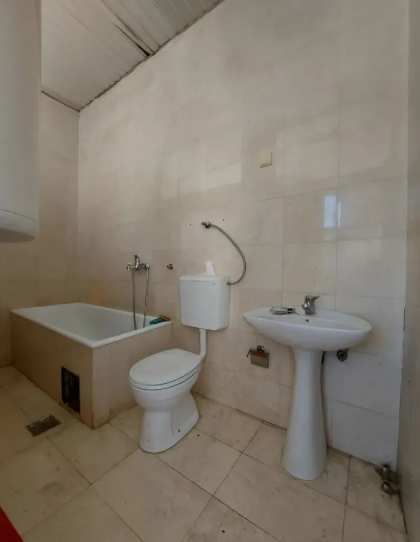 Small equipped bathroom with a bathtub, sink, and toilet.