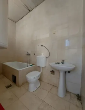 Small equipped bathroom with a bathtub, sink, and toilet. - image 15