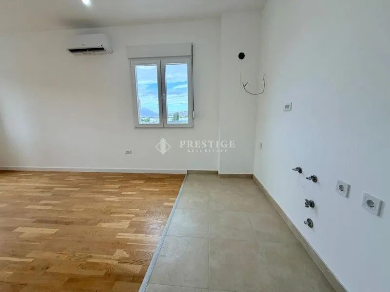 Prazna kuhinja sa parketom i keramičkim pločicama u novom stanu.