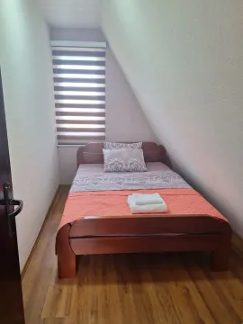 Manja spavaća soba sa bračnim krevetom ispod kosog krova. - image 8