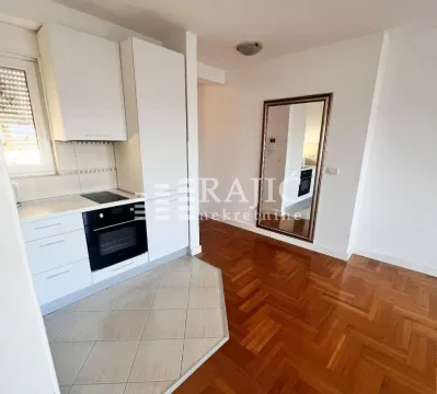 Small white kitchen with built-in hob and oven as part of an open plan space. - image 6