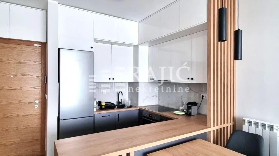 Modern kitchen with wooden elements and built-in appliances.