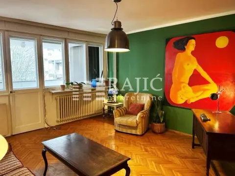 Living room with a green wall, a desk, and a large artwork. - image 14
