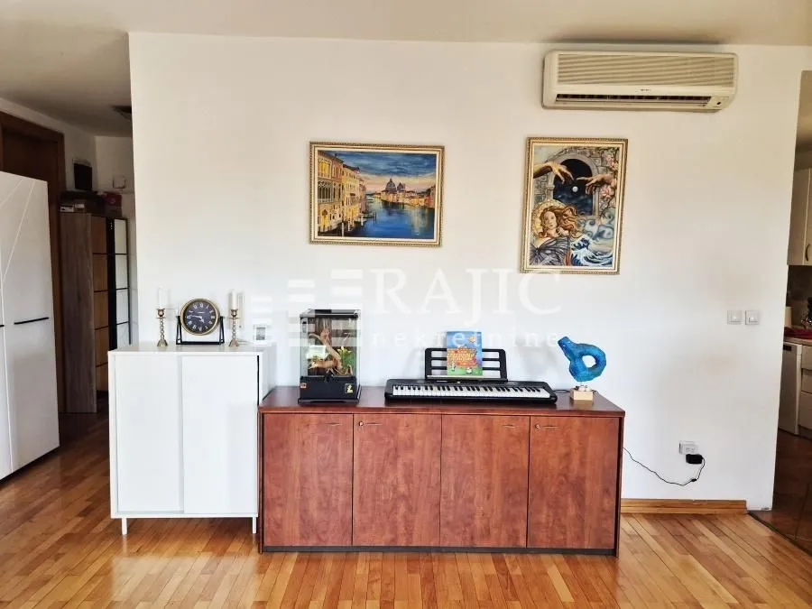 Living room with a sideboard, synthesizer and pictures on the wall.