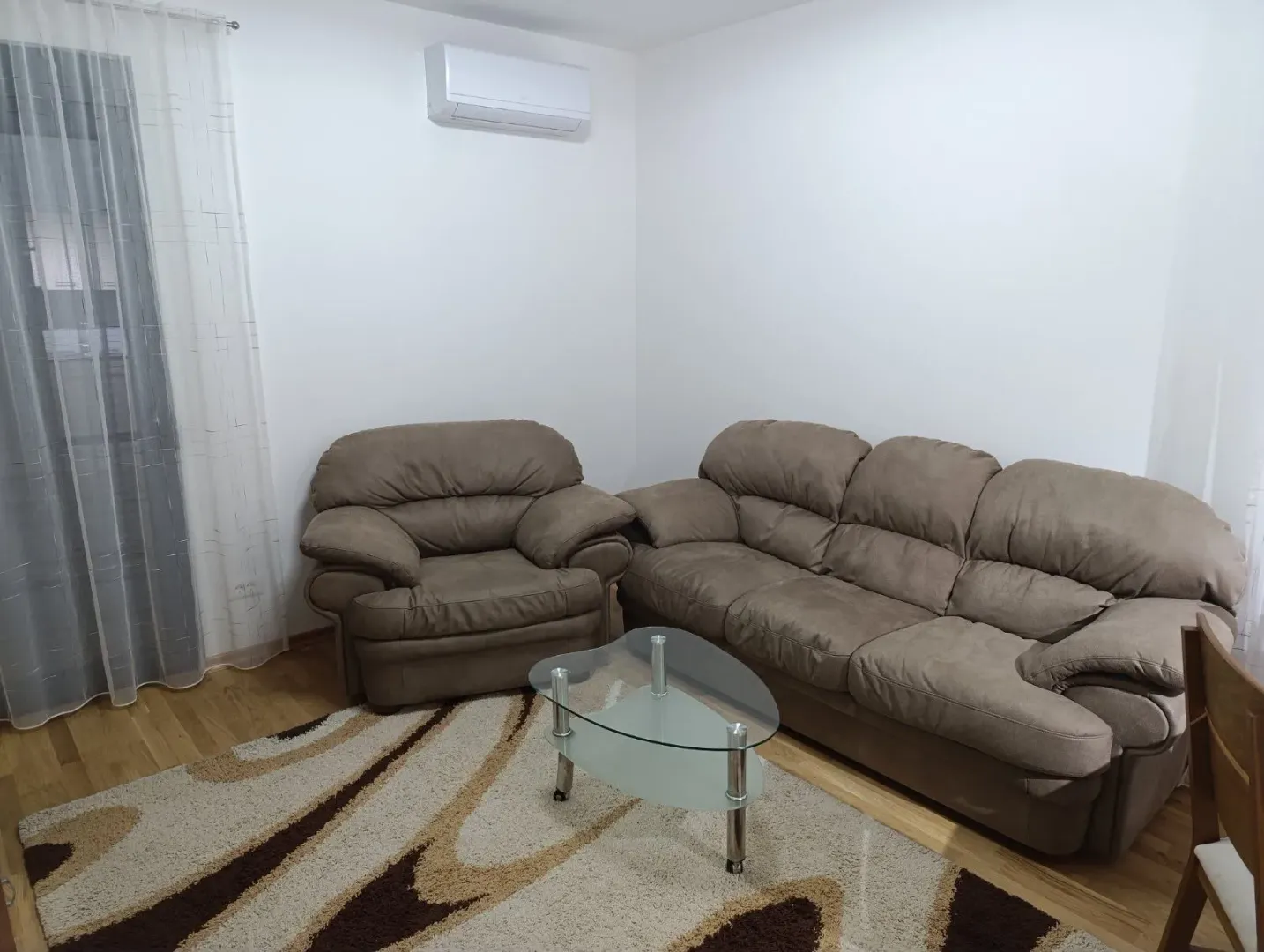 Dnevna soba sa garniturom, stočićem i klima uređajem.