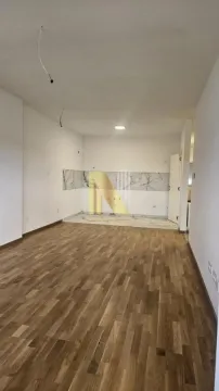 Empty room with wooden flooring and a prepared kitchen area. - image 2