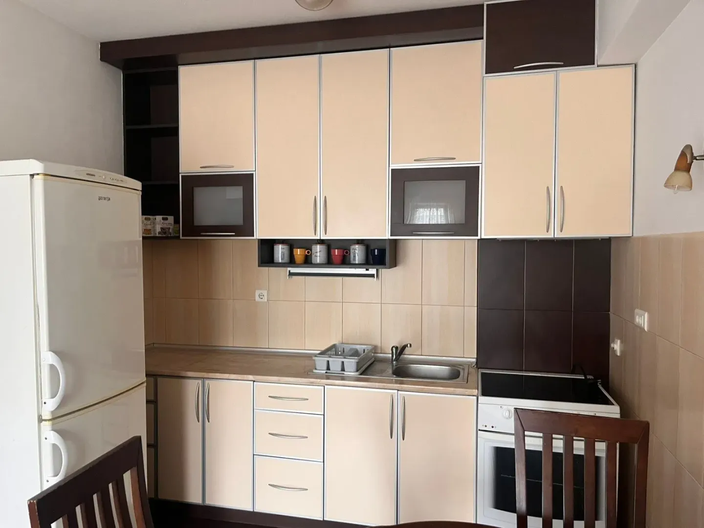 Small kitchen with fitted units, refrigerator and stove.