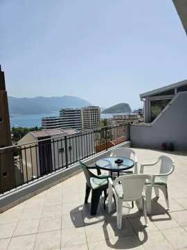 Spacious terrace with seating furniture and a view of the sea and city. - image 6