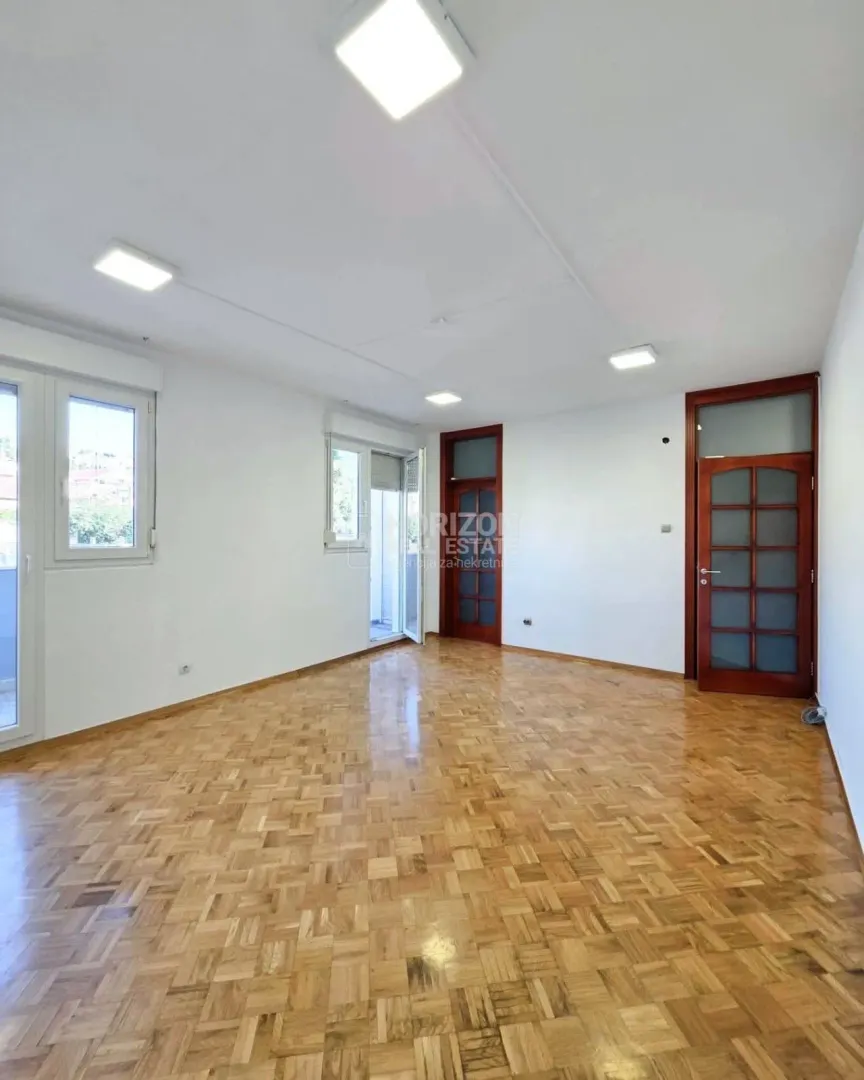 Empty room with parquet flooring and white walls.