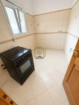 Small kitchen with wall tiles and an electric stove. - image 5