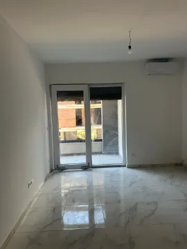 Prazna prostorija sa svijetlim pločicama i izlazom na terasu. - image 3