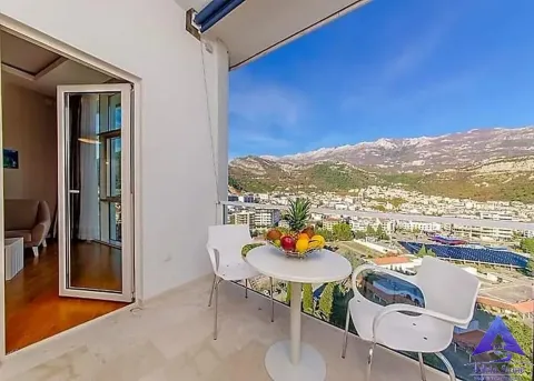 Namješten balkon sa stolom, stolicama i pogledom na grad i planine. - image 2