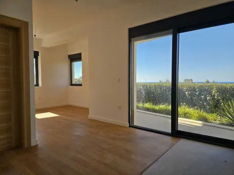 Empty living room with wooden flooring and large glass balcony doors. - image 3