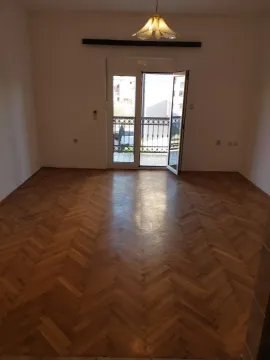 Prazna soba sa parketom i izlazom na balkon. - image 3