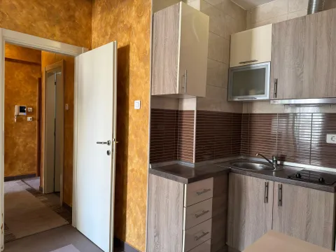 Small kitchen with wooden cabinetry and built-in appliances. - image 7