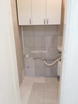 Small bathroom with tiles, washbasin, and wall cabinet. - image 3