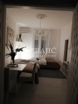Furnished bedroom with a bed and a desk. - image 3