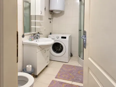 Kupatilo opremljeno umivaonikom, veš mašinom i tuš kabinom. - image 14