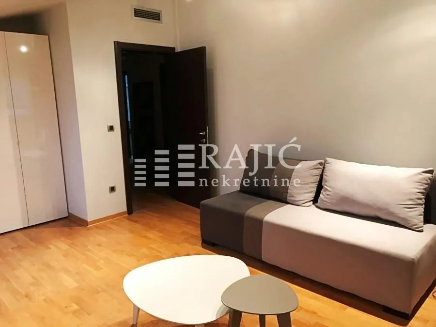 Living room with a sofa and parquet flooring.