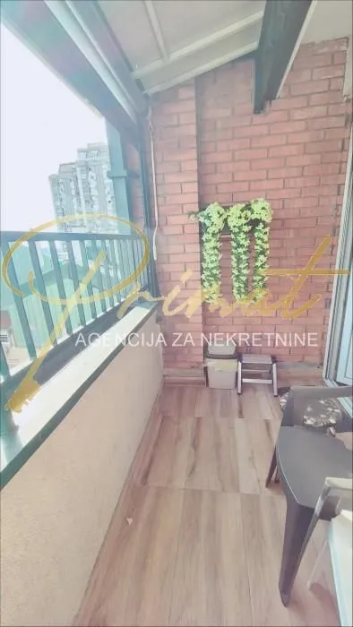 Covered terrace with a brick wall and wooden flooring.