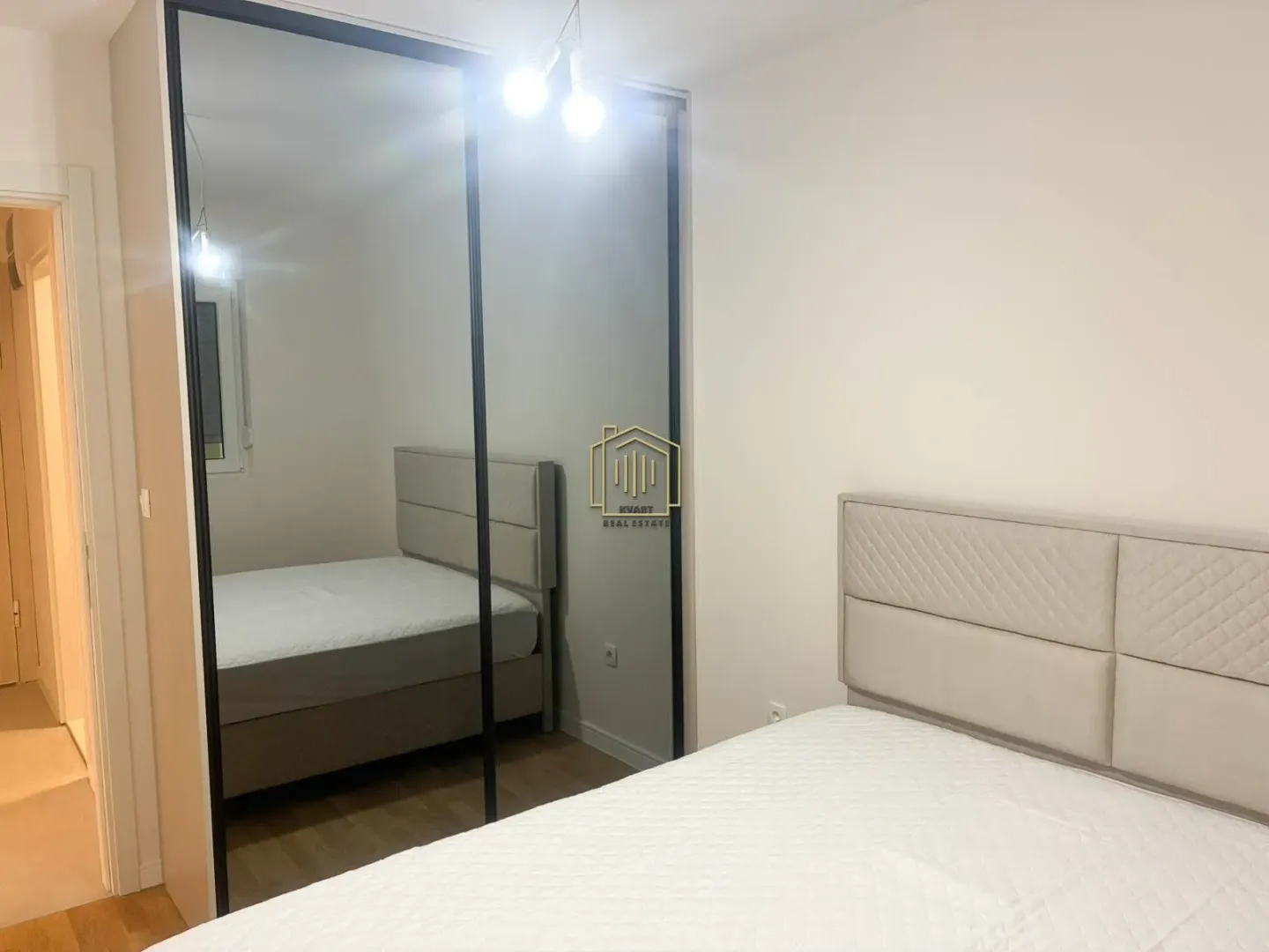Bedroom with a double bed and a large mirror on the wardrobe.