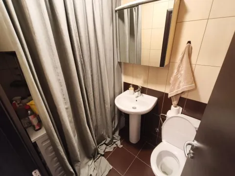 Compact bathroom with a sink, toilet, and shower enclosure with a curtain. - image 4