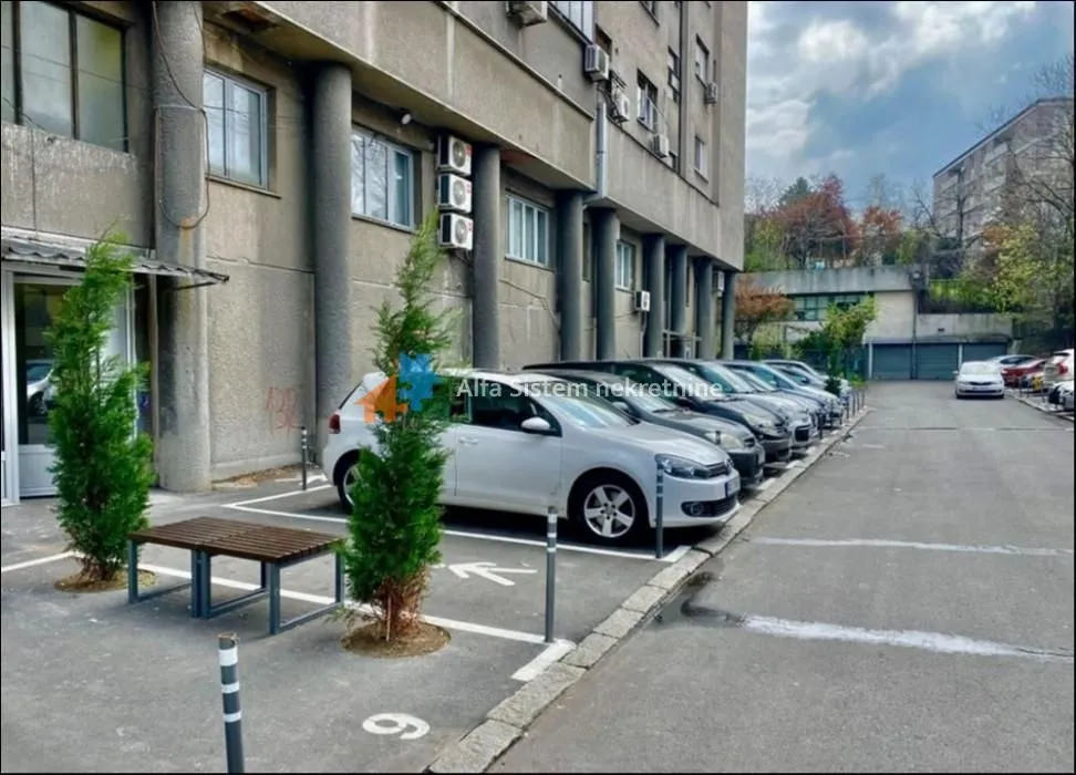 Pogled na spoljašnji prostor zgrade sa parking mestima.