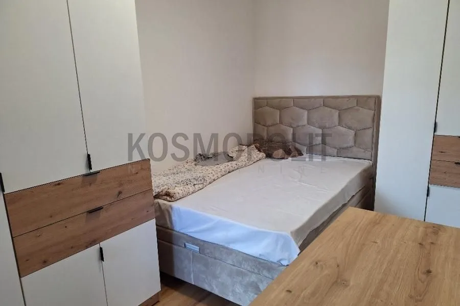 Nameštena spavaća soba sa bračnim krevetom i ugradnim garderoberima.