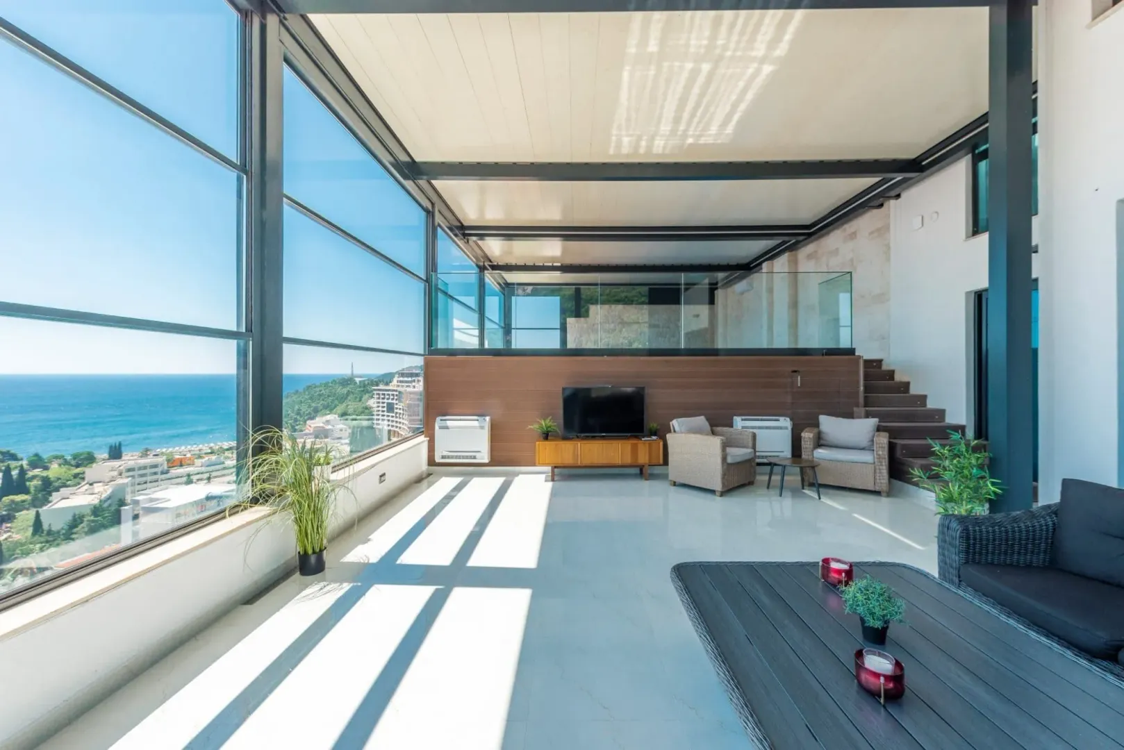Spacious glazed terrace with outdoor furniture and a beautiful sea view.