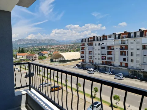 View from the terrace overlooking the street, neighboring buildings, and mountains in the background. - image 2