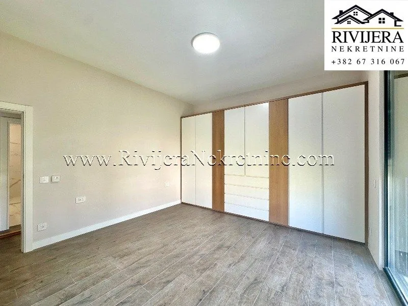 Bedroom with a large built-in wardrobe and wooden flooring.