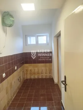 Empty tiled kitchen with a window and utility connections. - image 8