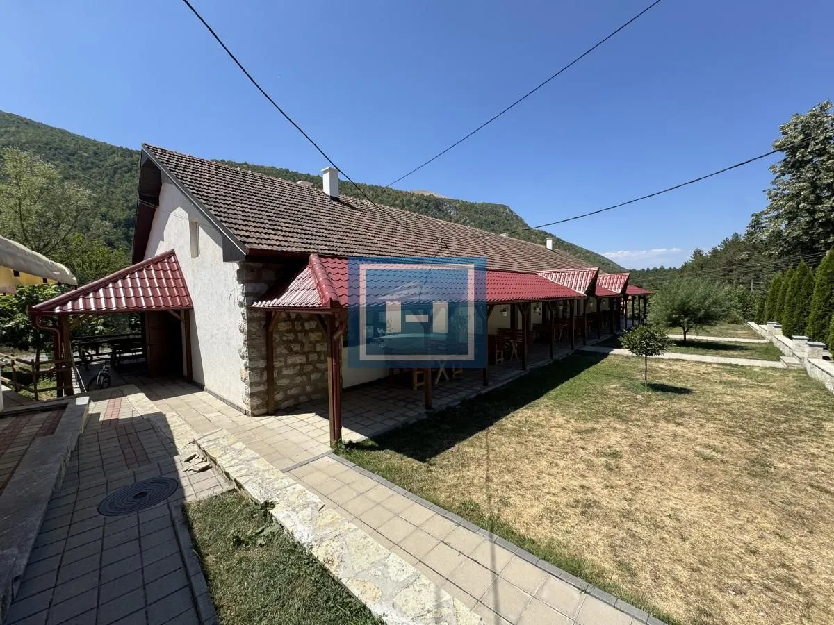 View of the exterior of the house with a yard and a covered terrace.