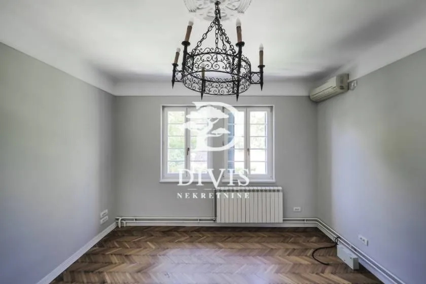 Empty room with parquet flooring, a chandelier, and an air conditioning unit.