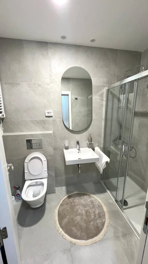 Moderne kupatilo sa tuš kabinom, umivaonikom i wc šoljom.