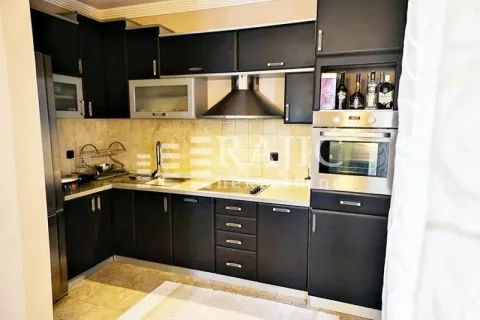 Modern kitchen with dark cabinetry and built-in appliances. - image 5