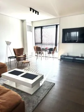 Spacious living room with a sofa, coffee table, and dining area. - image 5