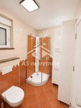 Kupatilo opremljeno tuš kabinom, WC šoljom i belim ormarićem. - image 14