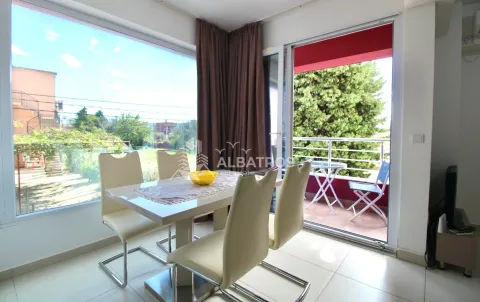 Dining area with a table and chairs and access to the terrace. - image 3
