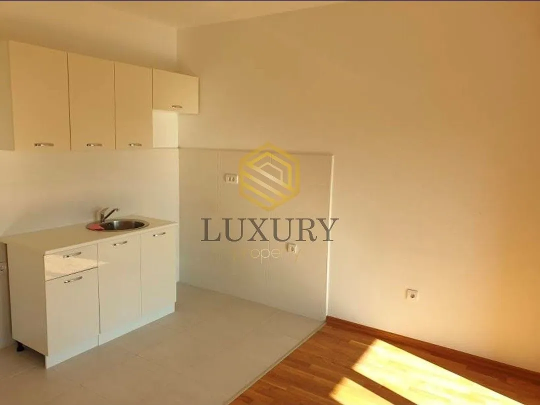 Small kitchen within a room with hardwood flooring.