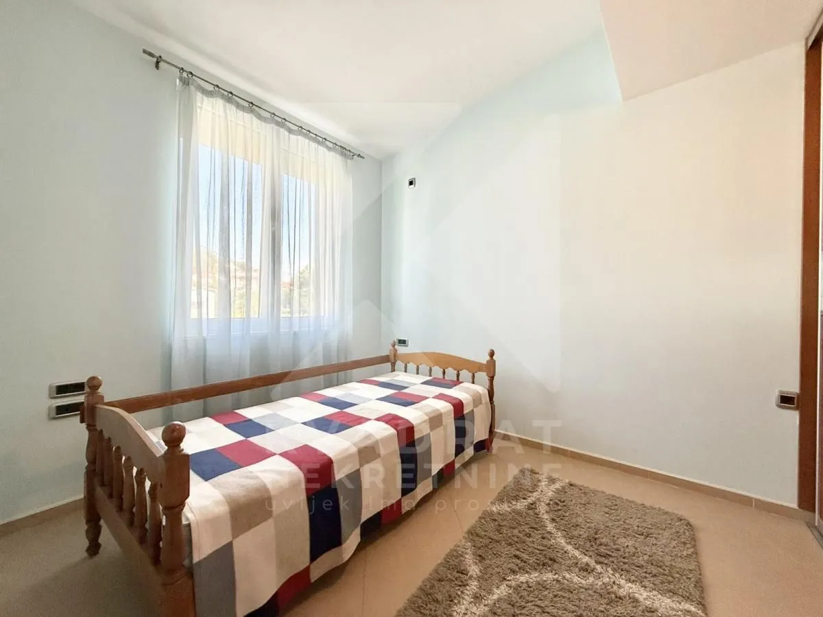 Smaller bedroom with a wooden bed and a window.