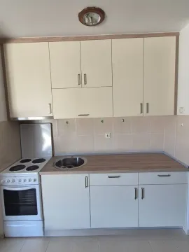 Small kitchen with white cabinets, sink, and stove. - image 4