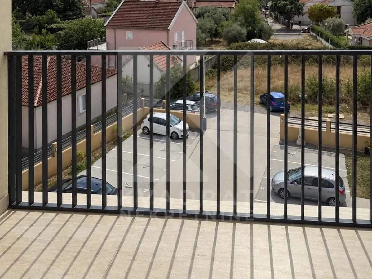 Pogled sa terase na parking prostor ispred zgrade.