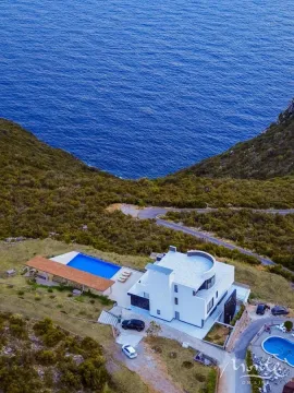 Aerial view of a villa with a swimming pool located near the seashore. - image 34