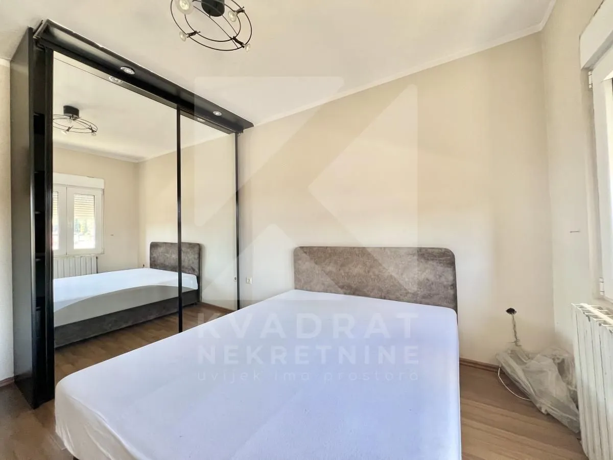 Bedroom with a double bed and a large mirrored wardrobe.