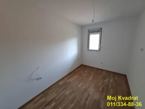 Prazna soba sa belim zidovima i drvenim podom. - image 4