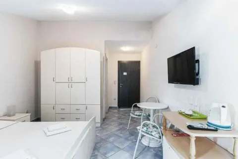 Spavaća soba sa velikim garderoberom, krevetom, trpezarijskim stolom i televizorom na zidu. - image 13